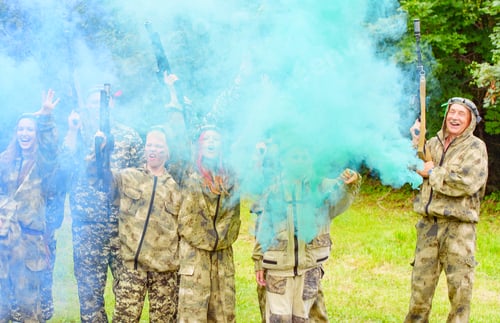 Preview: A Family In Camouflage Playing In Laser Tag Shooting Game With A Weapon Outdoor And Lights Colored