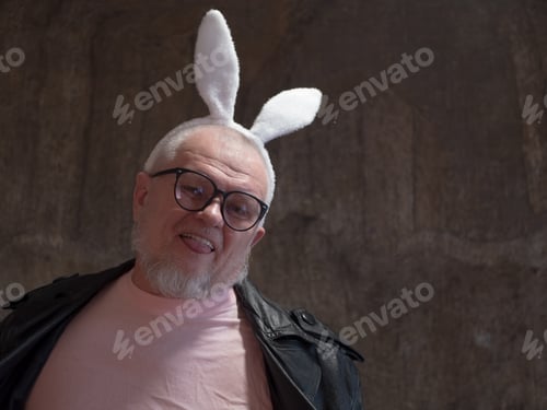 Preview: Elderly Man In Pink Pajamas, Rabbit Ears And Leather Coat Of Exhibition Maniac Is Dancing Against