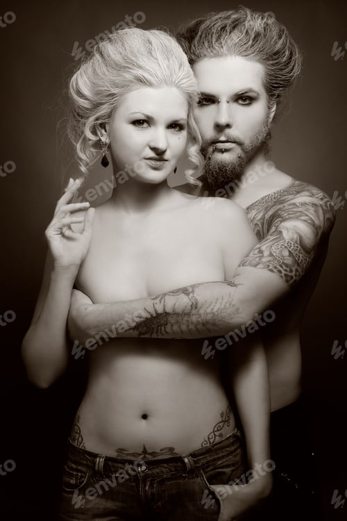 Preview: Duotone Shot Of Pierced Tattooed Man And Woman With Old-Fashioned Make-Up And Hairstyle