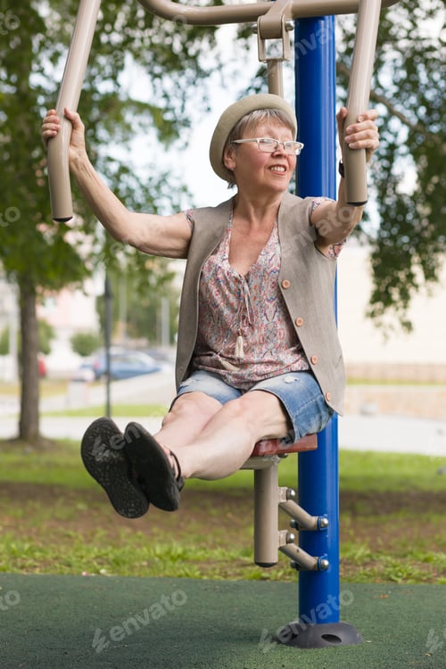 Preview: A Happy Elderly Woman Leads An Active Lifestyle, Practicing On Simulators In The City Park In The