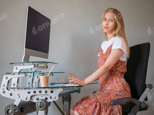 Preview: Slender Charming Blonde In White T-Shirt And Multi-Colored Sundress Poses In Front Of Camera In