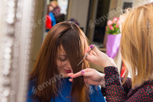 Preview: Close Up Of Blond Stylist Cutting Hair Of Young Brunette Client - Hair Dresser Cutting Angled Bangs