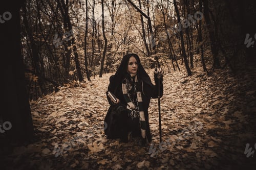 Preview: Charming Lady With Dreadlocks Wearing Black Mantle Standing By The Old Tree In The Autumn Forest