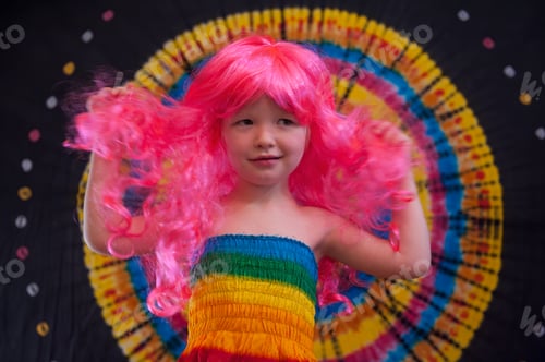 Preview: Happy Cute Caucasian Boy Changed Clothes At Carnival In Dress Of Girl Of Rainbow Color. Pink Doll