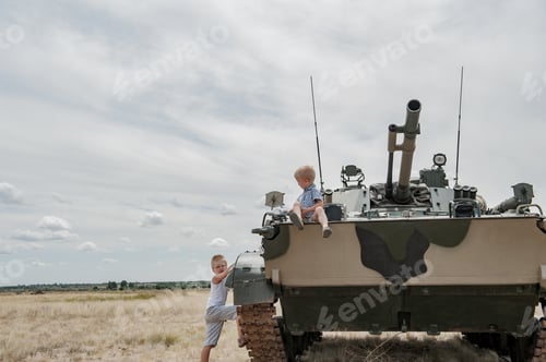 Preview: Two Children In Bright Clothes Climbed Onto Modern Battle Tank. Children Play Until There Are