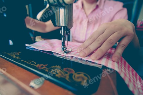 Preview: Closeup Of Woman Tailor Working With Old Sewing Machine At Home. Vintage Edited Photo.