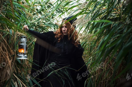 Preview: Witch With Light On A Swamp. Witch Practicing Magic On A Swamp. Halloween Concept