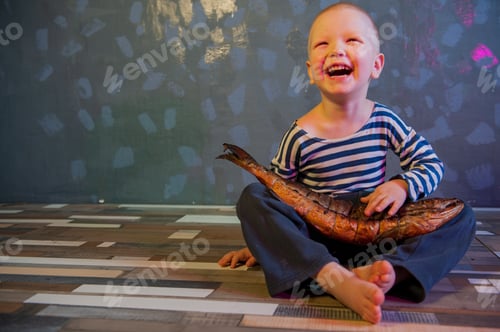 Preview: Little Blond Boy Shows Big Smoked Fish. Child Wants To Catch Big Fish In Ariver. Concept Of Organic
