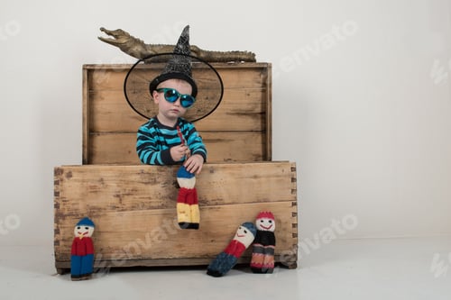 Preview: Happy Children In Elegant Green Clothes Play At Home With A Stuffed Crocodile And Rag Dolls. A Boy