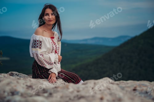 Preview: Attractive Woman In Traditional Romanian Costume On Mountain Green Blurred Background. Outdoor