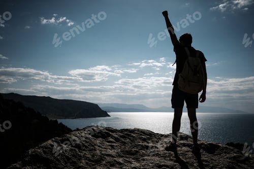 Preview: Hiker With Backpack Standing On Top Of A Mountain With Raised Hands And Enjoying View