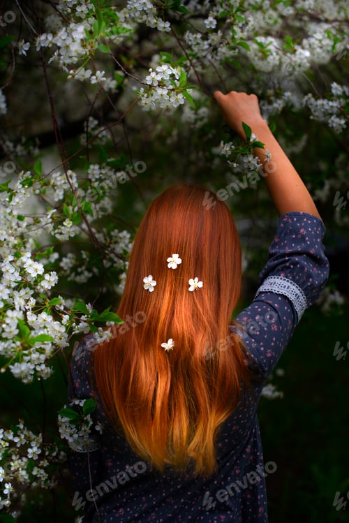 Preview: A Red-Haired Girl Stands From Back In A Blooming Garden With Flowers In Her Hair