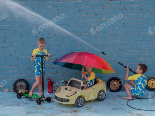 Preview: Funny Children In Boys' Bathing Suits Posing In Front Of Camera With High-Pressure Car Wash And Toy