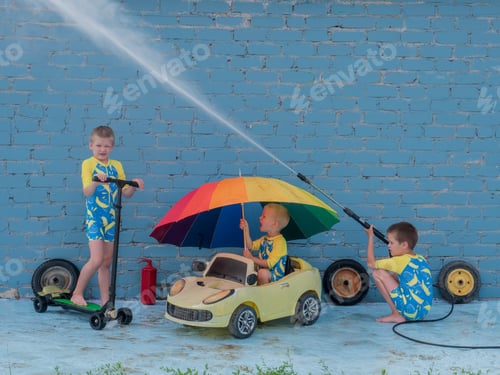 Preview: Funny Children In Boys' Bathing Suits Posing In Front Of Camera With High-Pressure Car Wash And Toy
