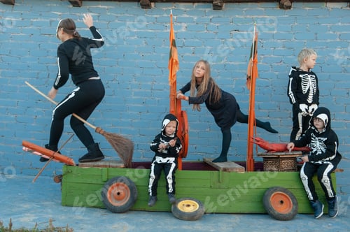 Preview: Cute Family In Skeleton Costumes For Halloween Celebrations Are Playing Pirates On Wooden Sailing