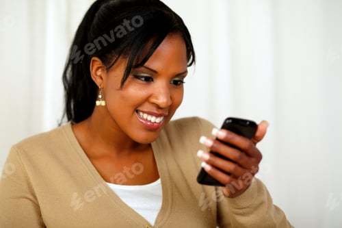 Preview: Portrait Of An Afro-American Young Woman Sending A Message By Her Mobile Phone