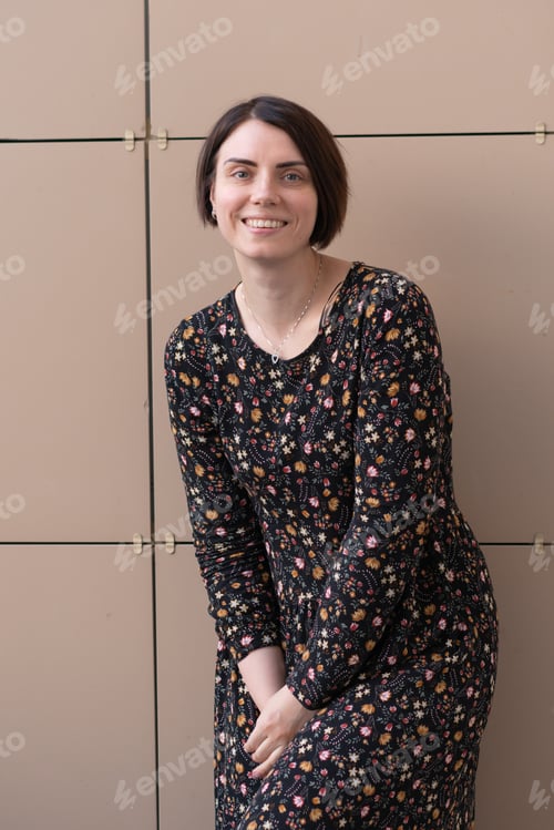 Preview: Portrait Of A Girl On The Balcony In The Summer, Standing In A Colored Dress Near The Beige Wall