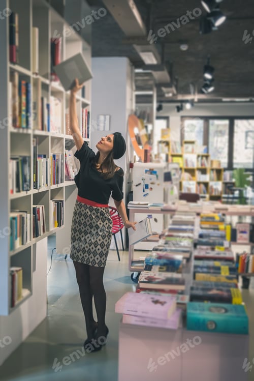 Preview: Beautiful Young Brunette With Turban Posing In A Bookstore