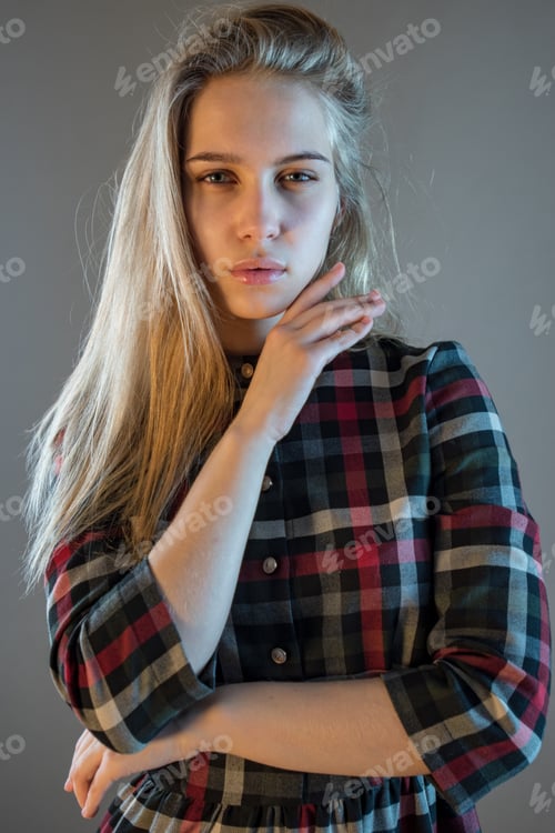 Preview: Young Blonde Girl In Plaid Dress Touches Her Hair. Woman Poses For Camera Demonstrating Natural
