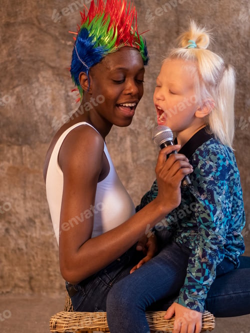 Preview: African American Woman In White Bodysuit And Jeans In Bright Multicolored Punk Wig And White Blond