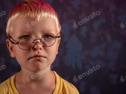 Preview: Cute Blond Child In Yellow T-Shirt And Glasses Posing In Front Of Camera And Smiling