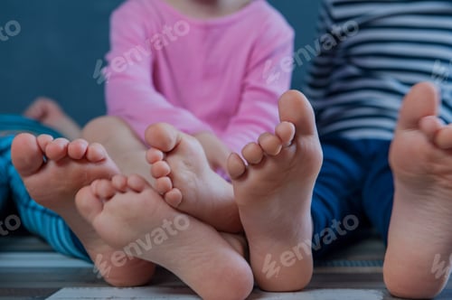 Preview: Three Children Are Sitting On Floor In Room And Are Going To Do Gymnastics. Legs And Feet Of Kids