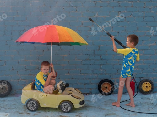 Preview: Funny Children In Boys' Bathing Suits Posing In Front Of Camera With High-Pressure Car Wash And Toy