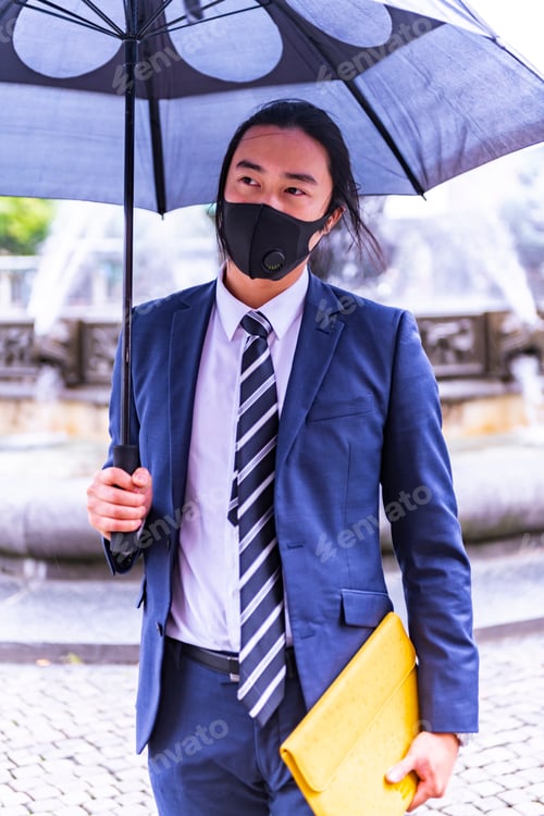 Preview: Handsome Asian Businessman Wearing Suit And Protective Face Mask (Covid 19) And Holding Umbrella