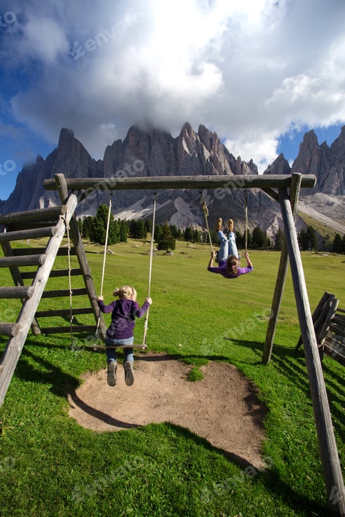 Preview: Girls Sister Swinging On A Swing In The Park Puez Odle. Italy