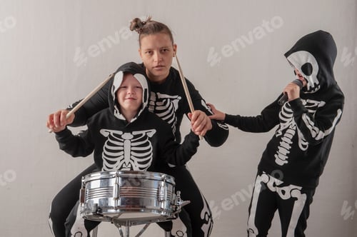 Preview: Happy Friendly Family Of Musicians In Carnival Costumes, Boys And Young Mother Play Drum And Try To