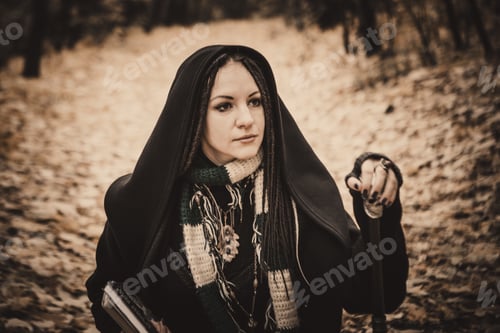 Preview: Charming Lady With Dreadlocks Wearing Black Mantle Standing By The Old Tree In The Autumn Forest