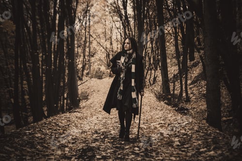 Preview: Charming Lady With Dreadlocks Wearing Black Mantle Standing By The Old Tree In The Autumn Forest