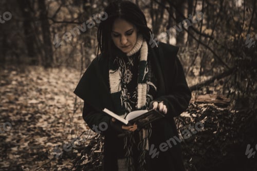 Preview: Charming Lady With Dreadlocks Wearing Black Mantle Reading, Standing By The Old Tree In The Autumn