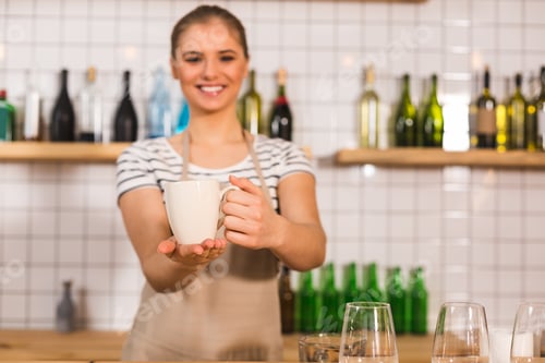 Visualização: Tão delicioso. Foco seletivo de uma xícara com chá sendo segurada por uma mulher agradável e encantada
enquanto