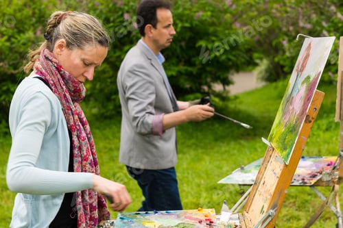 Preview: Couple Of Concentrated Artists In A Process Of Working On A Trestle And Easel Painting With Oils