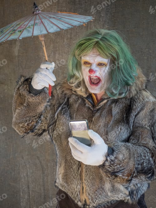 Preview: Crazy Aggressive Clown With Smartphone, Umbrella. Man Hates His Work And In His Free Time Dresses