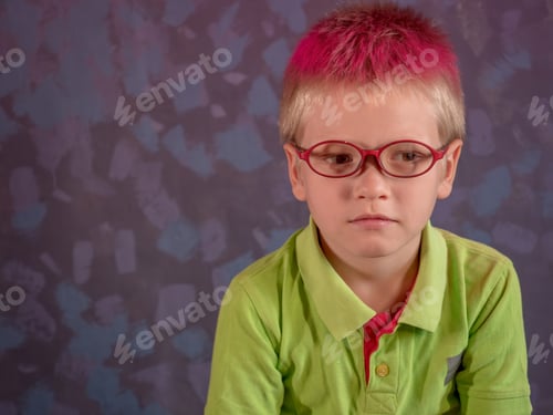 Preview: Cute Blond Child In Green Shirt And Glasses Posing In Front Of Camera And Smiling