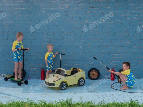 Preview: Funny Children In Boys' Bathing Suits Posing In Front Of Camera With High-Pressure Car Wash And Toy