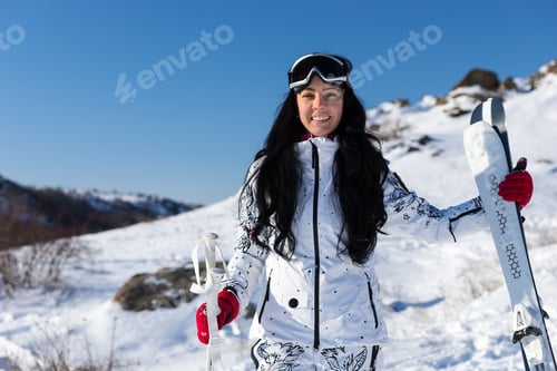 Preview: Half Body Shot Of A Pretty Young Female Skier Holding Her Equipment At The Mountain Resort, Smiling