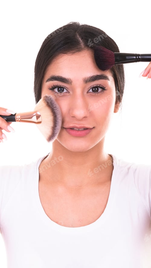 Vista previa: Hermosa joven sonriente aplica maquillaje con brocha. Aislado