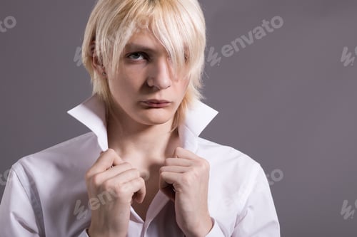 Preview: A Young Man With Stylish White Hair. Fashionable Guy In A White Shirt On A Gray Background.