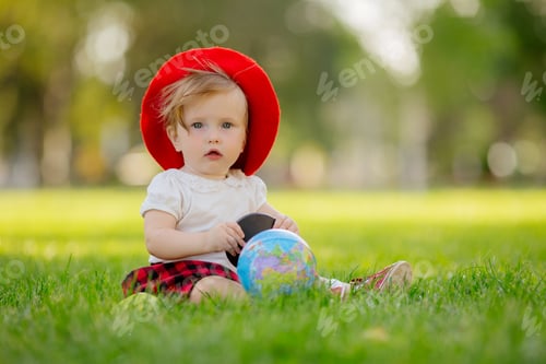 Preview: Baby Girl In The Image Of A Student Wearing Glasses With A Globe And An Empty Drawing Board On A