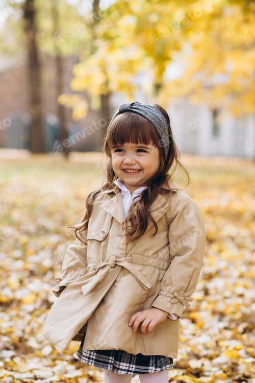 Preview: Happy And Beautiful Little Girl In A Beige Coat Walks In The Autumn Park