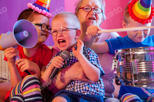 Preview: Elderly Woman In Pink T-Shirt And Glasses Holding Megaphone. Next To Grandmother, Grandchildren In