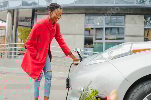 Preview: African American Girl Charging Electro Car At The Electric Gas Station