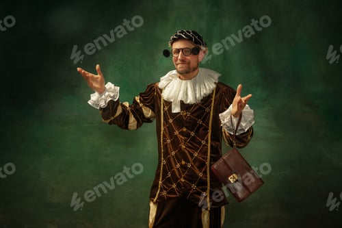 Preview: Trying New Eyewear. Portrait Of Medieval Young Man In Vintage Clothing With Wooden Frame On Dark