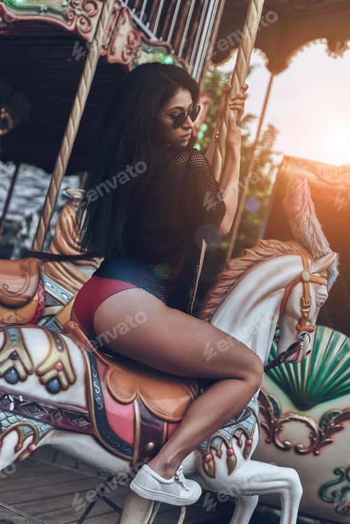 Preview: Riding Merry-Go-Round. Attractive Young Mixed Raced Woman In Red Bikini Riding Merry-Go-Round