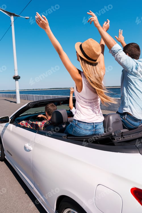Preview: Traveling With Fun. Rear View Of Young Happy People Enjoying Road Trip In Their Convertible And