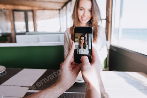 Preview: First-Person View Of Man Making Photo On Phone His Smiling Woman On Date In Cafe Near The Sea