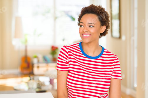 Preview: Young Beautiful African American Woman At Home Looking Away To Side With Smile On Face, Natural